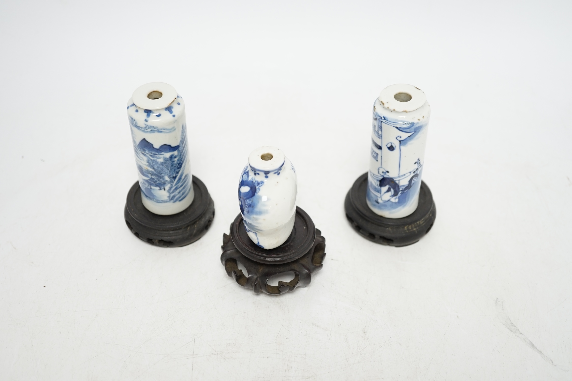 Three Chinese blue and white snuff bottles and three hardwood stands, largest 8cm high. Condition - poor to fair